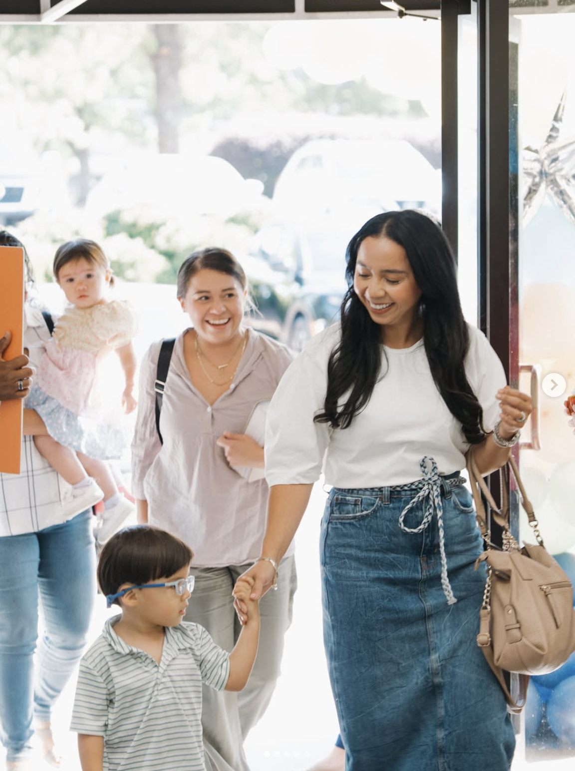 Smiling families walking through the church doors on a Sunday morning